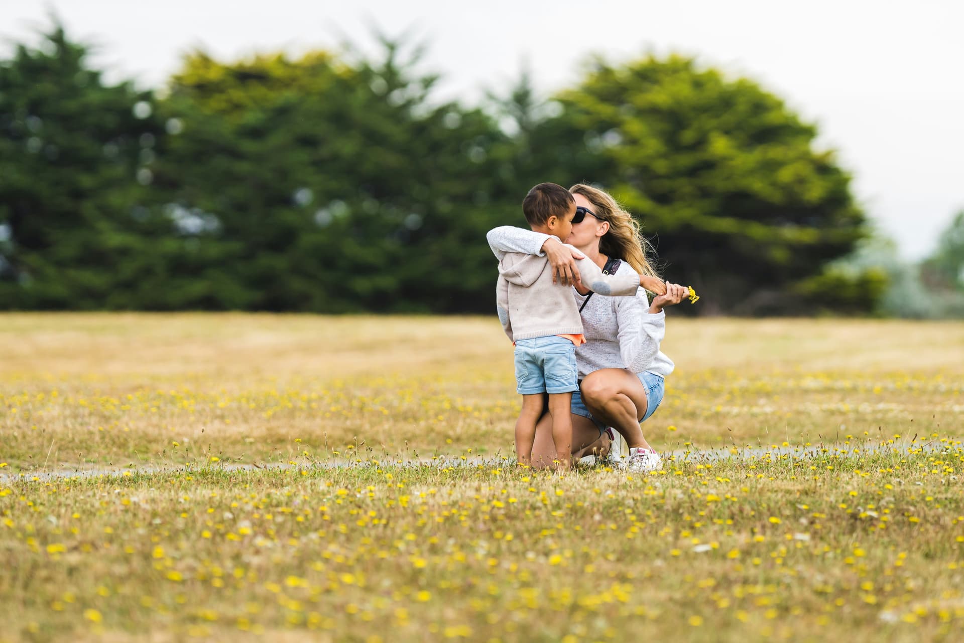 Mother and son kissing in a field